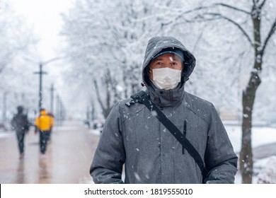 Portrait of a man wearing a medical protective mask on his face in winter, Covid-19 coronavirus pandemic, virus protection.