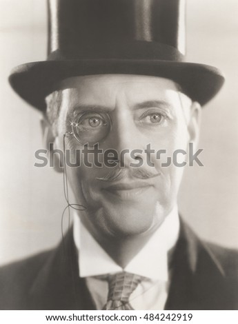 Portrait of man wearing monocle and top hat