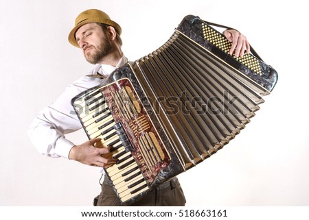 Portrait of a man wearing a straw hat and a white shirt emotionally playing the accordion