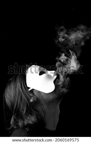 Portrait of a man wearing white mask with smoke coming out of his mouth in black background. Black and white. Soft focus