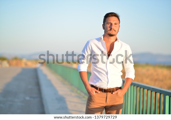 portrait of man\
wearing white shirt at the\
beach