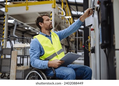 Portrait of man in wheelchair working in modern industrial factory, in adjustable workstation. Concept of workers with disabilities, accessible workplace for employees with mobility impairment. - Powered by Shutterstock