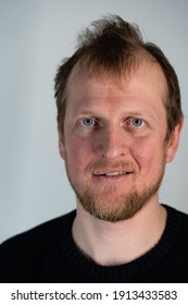 Portrait Of A Man Where He Looks Straight And Smiles With Frizzy Hair When He Can See His Teeth