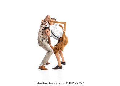Portrait of man and woman appearing from picture frame, posing isolated over white background. Retro style. Concept of news, style, fashio, business, office lifestyle, success, expression, ad