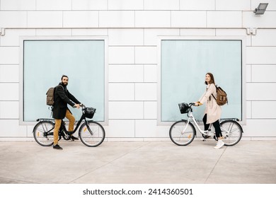 Portrait of man and woman with e-bikes standing at a building - Powered by Shutterstock