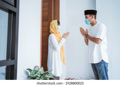 Portrait Of Man And Woman Visiting Home During Eid Mubarak Wearing Medical Mask To Protect From Covid 19 And Keep Social Distancing