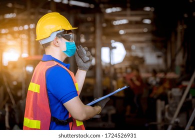 Portrait man worker under inspection and checking production process on factory station by wearing safety mask to protect for pollution and virus in factory. - Powered by Shutterstock