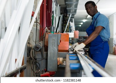 Portrait of man worker who is occupation near special machine in the pvc workshop.
