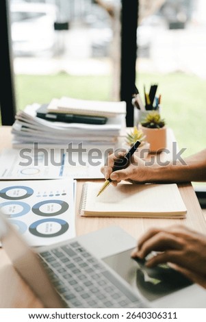 Portrait of a man working with documents using laptop in modern office. Preparing accounting analysis report, real estate investment information, finance and tax concept.