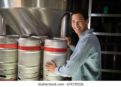 Portrait of manager checking beer keg in warehouse of restaurant - Powered by Shutterstock