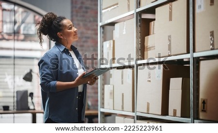Portrait of a Manager Checking Inventory, Writing in Tablet Computer. Black Woman Working in a Warehouse Storeroom with Rows of Shelves Full of Parcels, Packages with Orders Ready for Shipment.