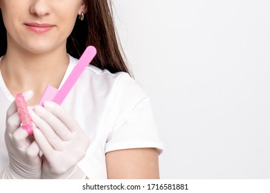 Portrait of manicure master is holding manicure tools in her hands on white background with copy space. - Shutterstock ID 1716581881