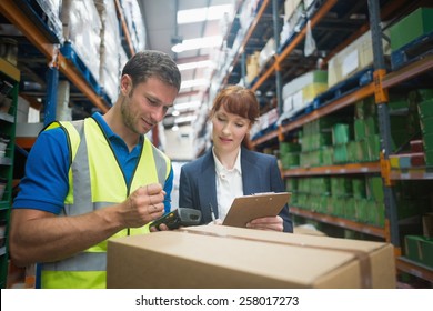 Portrait of manual worker and manager scanning package in the warehouse - Powered by Shutterstock