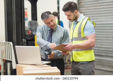 Portrait of manual workers scanning package in the warehouse - Powered by Shutterstock