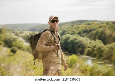 Portrait of masculine fisher hunter man with hatchet axe wearing tactical gear exploring the river outdoors landscape - Shutterstock ID 2194659603