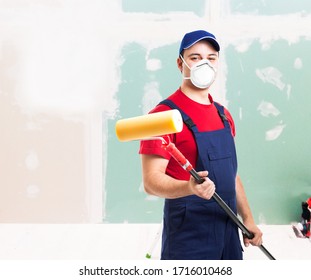 Porträt eines maskierten Malers bei der Arbeit in einer Wohnung, Renovierung und Hausmalerei während der Koronavirus-Pandemie