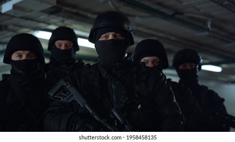 Portrait Of Masked SWAT Police Officers Posing At Camera. Police Special Forces In Helmets Holding Assault Rifles. Military Soldiers Looking At Camera. Anti Terrorist Squad At Operation 