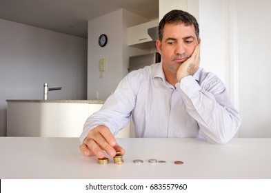 Portrait of mature adult businessman (male age 40 - 50) with worried facial expression sitting at home table worried about banking financial problems. Money crisis concept.  Real people. Copy space - Powered by Shutterstock