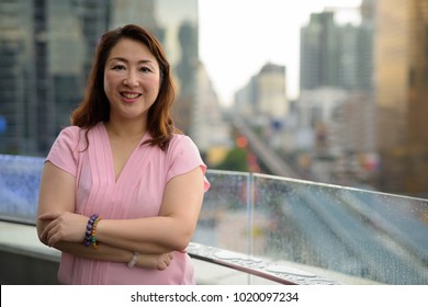 Portrait Of Mature Asian Woman Against View Of The City In Bangkok, Thailand