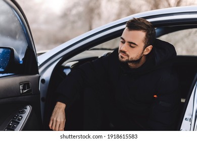 Portrait Of Mature Beard Man Thinking And Sitting In The Car. Man Taking A Break On Road Trip. Man In Black Puffer Jacket Look Calm.