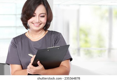 Portrait Of Mature Business Woman Holding A Clipboard