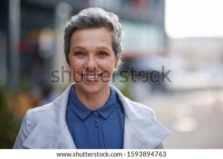 Portrait mature business woman smiling looking confident in city female success testimonial
