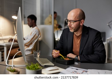 Portrait Of Mature Businessman Eating Takeout Dinner While Working Late At Night In Office, Copy Space