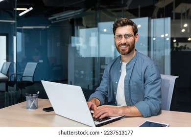 Portrait of mature businessman inside modern office, senior man in shirt smiling and looking at camera, worker using laptop at work. - Powered by Shutterstock