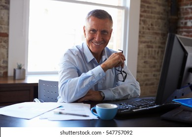 Portrait Of Mature Businessman Working In Office