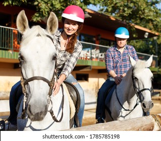 Portrait Of Mature Couple In Helmets  Riding By Horse At  Barn At Summer Day