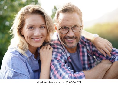 Portrait of mature couple relaxing in outdoor sofa