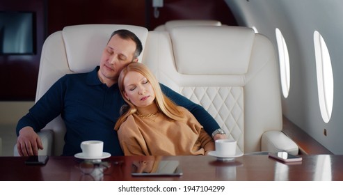 Portrait Of Mature Couple Sleeping In Luxurious Private Jet. Married Elegant Man And Woman Napping In First Class Interior Of Airplane During Flight