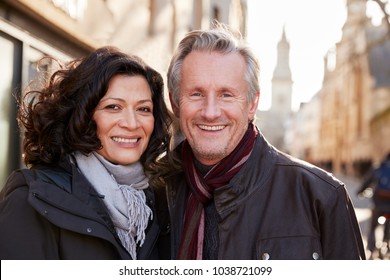 Portrait Of Mature Couple Walking Through City In Fall Together