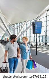 Portrait Of Mature Couple Walking While Talking In Airport