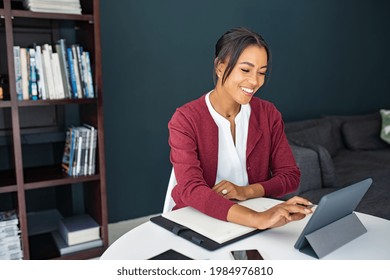 Portrait Of Mature Executive Businesswoman Using Digital Tablet While Working From Home. African Mature Woman Working On Laptop At Home. Happy Smiling Mid Adult Woman Making Notes In Smart Working.