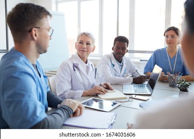 Portrait Of Mature Female Doctor Heading Committee Meeting At Medical Council, Copy Space