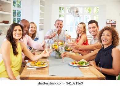 Portrait Of Mature Friends Around Table At Dinner Party