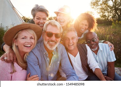 Portrait Of Mature Friends By Tent On Camping Vacation Against Setting Sun - Shutterstock ID 1549485098