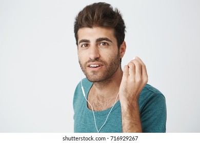 Portrait Of Mature Good Looking Caucasian Male With Stylish Hairstyle And Beard, In Blue Tshirt, Taking Off Headphone When Man On Street Asked How To Get To The Main Street.