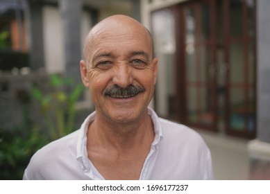 Portrait сlose up mature happy hairless man looking at camera with toothy smile