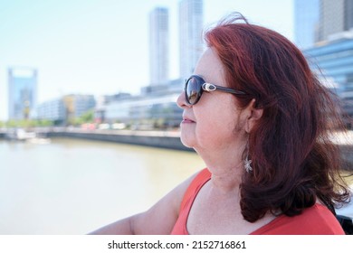 Portrait Of A Mature Hispanic Woman Enjoying A Summer Day In Puerto Madero, A Trendy Neighborhood In Buenos Aires, Argentina. Concepts: Traveling And Enjoying The Outdoors, Active Retirement.