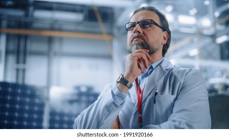 Portrait Of Mature Male Engineer Confident And Focused Thinking, Working At Aerospace Satellite Manufacturing Facility. Top World Scientists Doing Science And Technology Research In Space Program