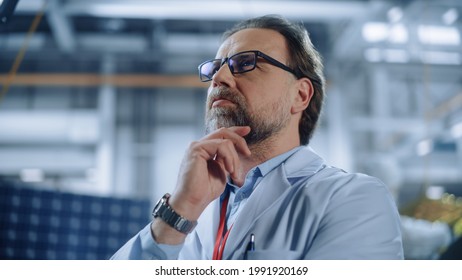 Portrait Of Mature Male Engineer Confident And Focused Thinking, Working At Aerospace Satellite Manufacturing Facility. Top World Scientists Doing Science And Technology Research In Space Program