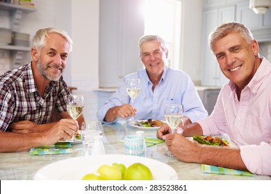 Portrait Of Mature Male Friends Enjoying Meal At Home