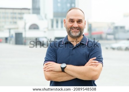 Portrait of a mature man 45 50 years old, who stands against the background of the city.