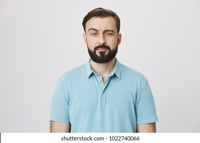 Portrait Of A Mature Man With A Beard And Moustache Looking Suspicious. Person Lifts His Eyebrow And Do Not Really Believe In The Words He Hears, Looking A Little Bit Gloomy.