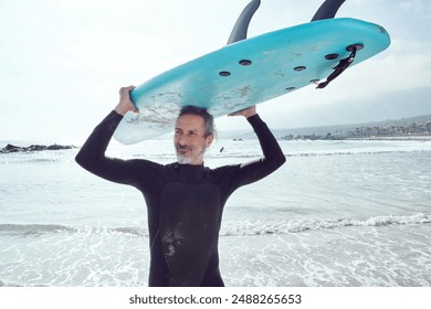 portrait mature man carrying a surfboard on his head on the beach shore - Powered by Shutterstock