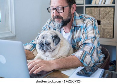 Portrait Of Mature Man And Dog Working Together At Laptop Computer With Love And Friendship - Modern Job Lifestyle In Home Office - Concept Of Online Work And New Job Career For Businessman