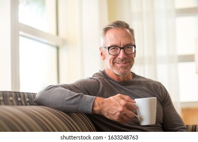 Portrait Of A Mature Man Drinking Coffee Sitting By The Window.￼