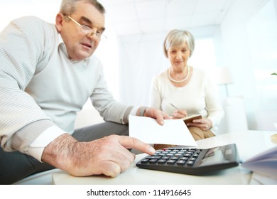 Portrait Of Mature Man And His Wife Making Financial Revision At Home